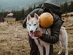 Hund wird von Mann umarmt 