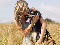 Frau mit Hund im Weizenfeld