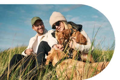 mera zwei Menschen mit zwei Hunden auf einer Wiese mera zwei Menschen mit zwei Hunden auf einer Wiese