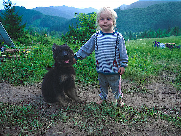 Kleiner Junge steht mit Hund am Feldrand Kleiner Junge steht mit Hund am Feldrand