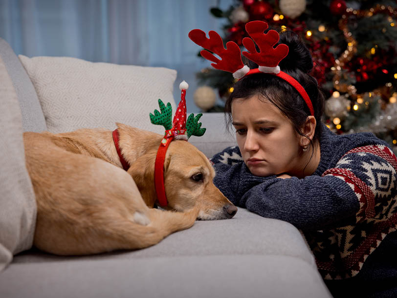 Hund und Frau liegen erschöpft auf der Sofa