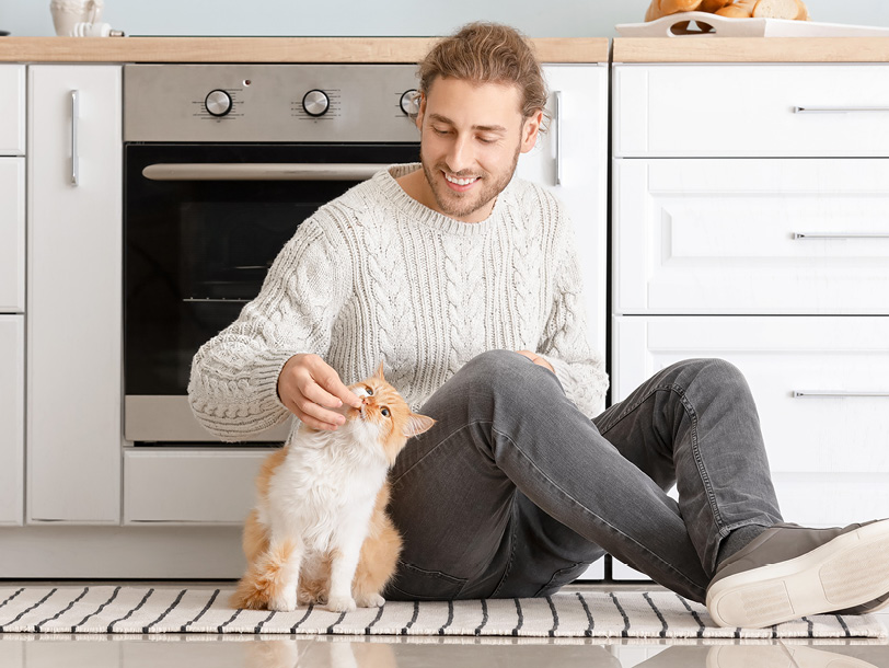 Mann mit Katze in einer Küche